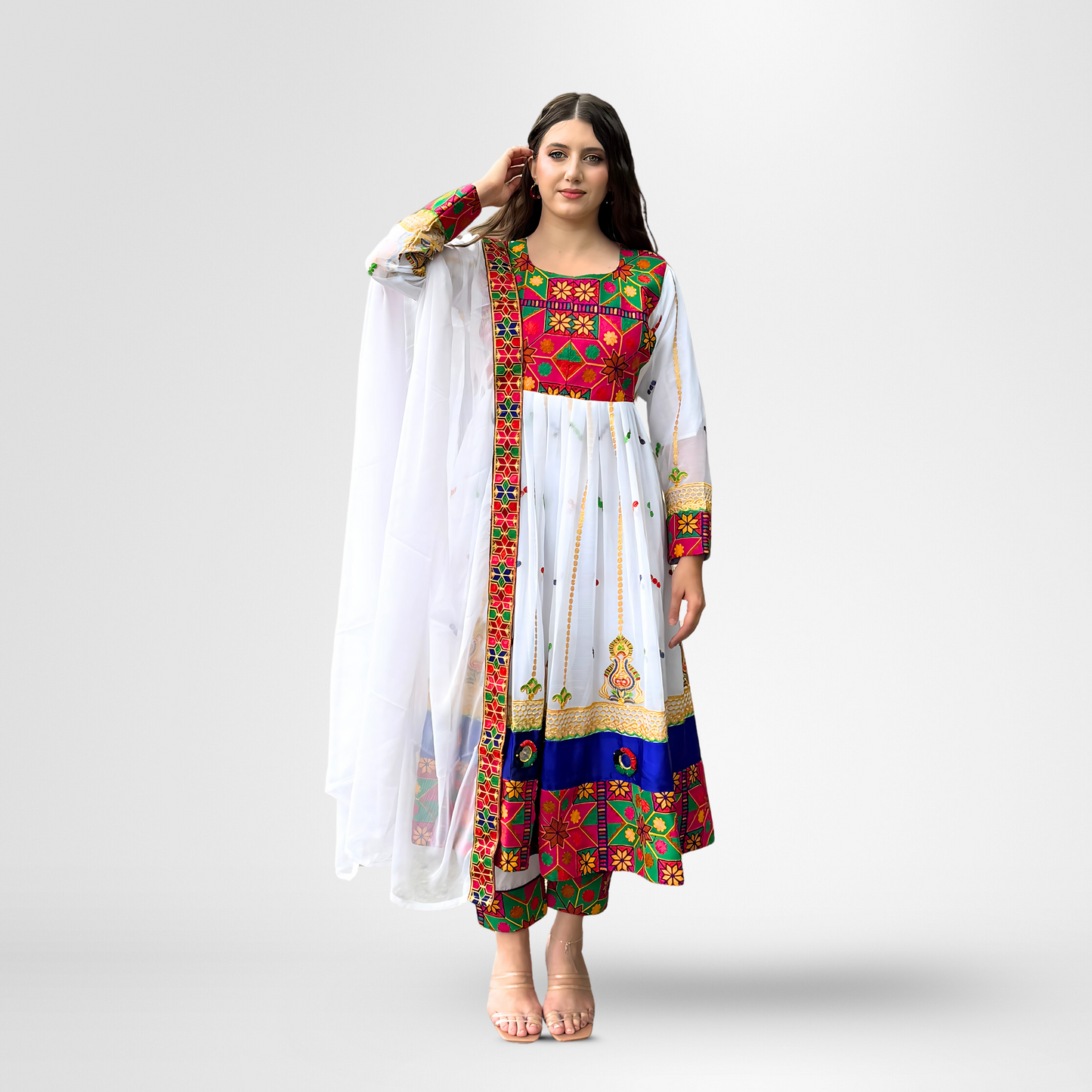 Woman wearing a white traditional dress with red, green, blue, and gold embroidery, Chandani.